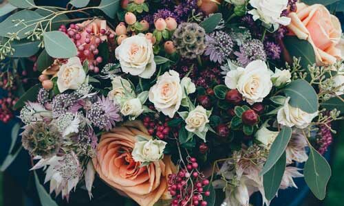 une femme tenant un bouquet de fleurs, dans ses mains