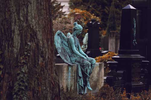 statue triste assise sur une tombe