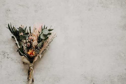 des fleurs séchées sur du béton ciré