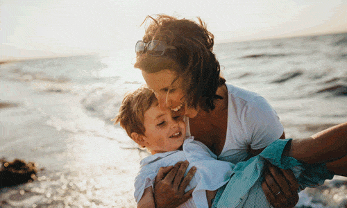 une mère tenant un enfant à la plage
