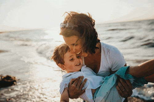une mère tenant un enfant à la plage